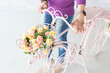 woman with flower basket on a bike