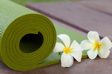 green yoga mat and a flower outdoor, healthy and sport concept