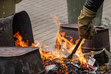A Technician Wearing Fire Resistant Gloves Places Raku Ware Into A Reduction Fire