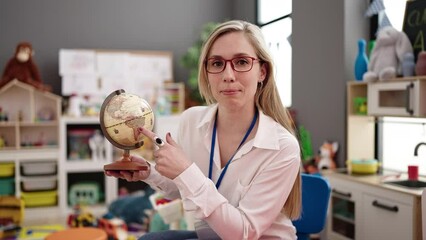 Poster - Young blonde woman preschool teacher having geography lesson at kindergarten