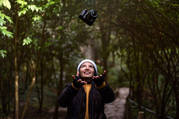 Latin woman throwing a camera in nature