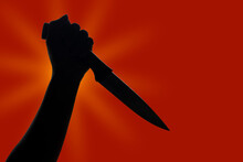 Silhouette Holding Knife On Red Gradient Background
