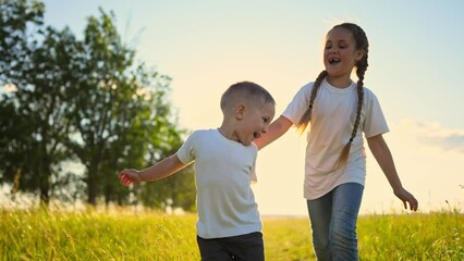 Wall Mural - happy family kids. people in the park children child running together in the park at sunset silhouette. mom dad daughter and son are fun run happy family and little child in summer. dream kids run