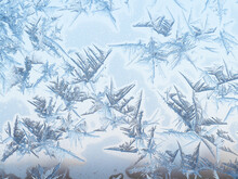 Natural Blue Frost Pattern On Window Glass Closeup On Cold Winter Day