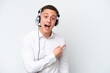 © luismolinero - Telemarketer Brazilian man working with a headset isolated on white background surprised and pointing side