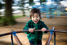 A Young Boy Screams With Excitement While On A Merry-go-round.