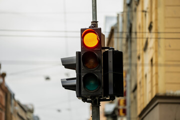 Poster - Black red traffic light with city buildings in background