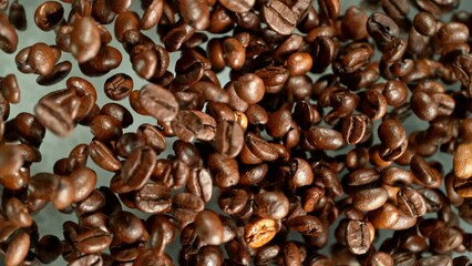 Poster - Super slow motion of rotating coffee beans on black background. Filmed on high speed cinema camera, 1000 fps placed on high speed cine bot.  Camera moving up with rotation.