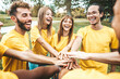 © Davide Angelini - Multi ethnic young people team stacking hands together outside - International university students support and help each other - Friendship, team building, human relationship and diversity concept