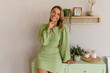 © mary_markevich - young stylish smiling woman in green summer dress in modern interior apartment home