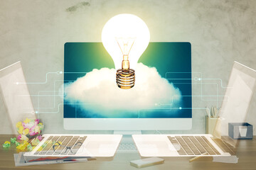 Poster - Computer on desktop in office with bulb icon hologram. Double exposure. Concept of idea.