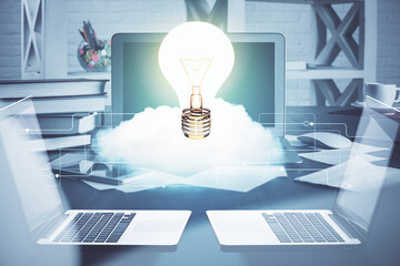 Poster - Computer on desktop in office with bulb icon hologram. Multi exposure. Concept of idea.