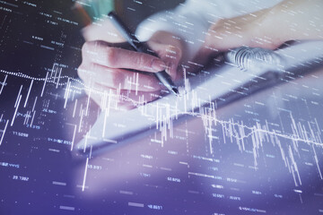 Poster - Financial forex graph displayed on hands taking notes background. Concept of research. Double exposure