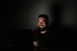 © Ринат Куйшин - man laughing looking at laptop in the dark