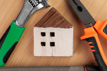 Wooden figurine of a residential house with a set of construction tools