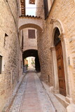Fototapeta Tęcza - Archway in a old narrow alley in Spello, Umbria Italy