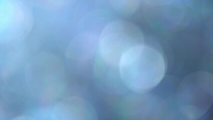 Wall Mural - Glimmer blue bokeh moving background. Fading illuminated blue defocused circles shimmer, shine and sparkle in an abstract way. Relaxing 4K moving background can be used as an overlay or transition.
