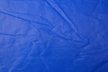 Sheet of crumpled blue paper as background, top view