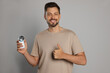 © New Africa - Handsome man holding fabric shaver on light grey background
