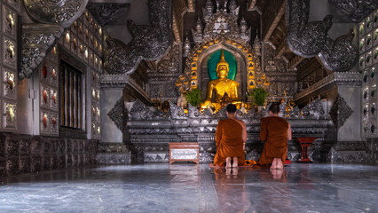 Monks front of the Buddha statue inside the Silver Temple