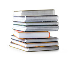 Many Books In A Pile Stand On The Table On Isolated White Background.
