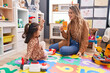 © Krakenimages.com - Teacher and toddler sitting on table having language lesson at kindergarten