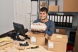 © Krakenimages.com - Young hispanic man ecommerce business worker preparing clothes package at office