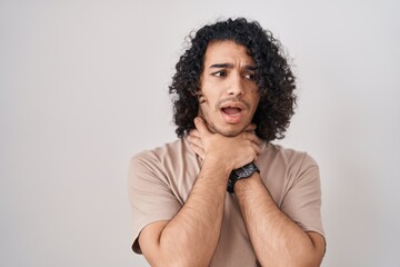 Sticker - Hispanic man with curly hair standing over white background shouting suffocate because painful strangle. health problem. asphyxiate and suicide concept.