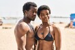 © Krakenimages.com - African american man and woman couple wearing swimsuit hugging each other at seaside