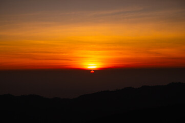 Wall Mural - panorama aerial view sunset , sunrise over dark mountain with fog over the ground.the early evening 