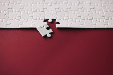 Wall Mural - Clean puzzle elements on the red background. Empty puzzle piece on the table. Teamwork concept.