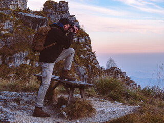 traveler photographer takes a photo of an italian alpine landscape with a professional camera