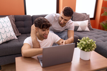 Sticker - Two hispanic men couple using laptop sitting on sofa at home