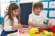 © Krakenimages.com - Brother and sister playing with construction blocks sitting on table at kindergarten