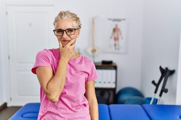 Poster - Middle age blonde woman at pain recovery clinic looking stressed and nervous with hands on mouth biting nails. anxiety problem.