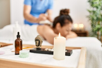 Poster - Middle age man and woman wearing therapist uniform having back massage session using thai bags at beauty center