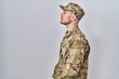 © Krakenimages.com - Young hispanic man wearing camouflage army uniform looking to side, relax profile pose with natural face with confident smile.