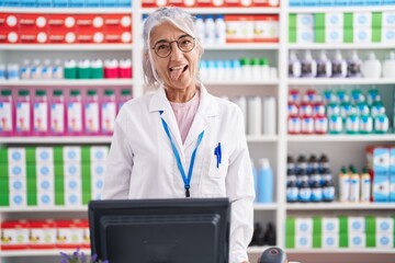 Sticker - Middle age woman with tattoos working at pharmacy drugstore sticking tongue out happy with funny expression. emotion concept.