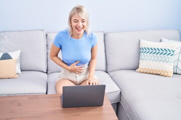 Sticker - Young blonde woman watching movie on laptop at home