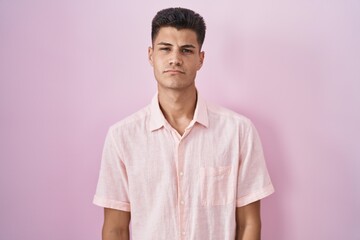 Sticker - Young hispanic man standing over pink background looking sleepy and tired, exhausted for fatigue and hangover, lazy eyes in the morning.