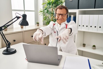 Poster - Senior doctor man working on online appointment pointing to you and the camera with fingers, smiling positive and cheerful