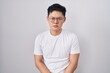 © Krakenimages.com - Young asian man standing over white background skeptic and nervous, frowning upset because of problem. negative person.