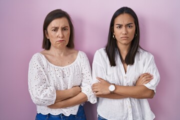 Wall Mural - Hispanic mother and daughter together skeptic and nervous, disapproving expression on face with crossed arms. negative person.