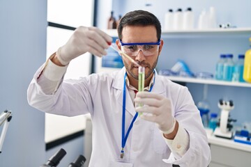 Sticker - Young hispanic man scientist measuring liquid at laboratory