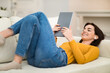 © Prostock-studio - Relaxed young woman chilling on couch at home, watching movie