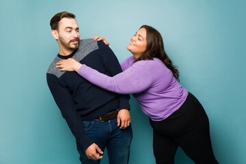 Wall Mural - Young woman flirting with an upset caucasian man