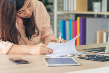 Sticker - Asian Female freelance using laptop at home office desk. Woman reading financial graph chart Planning analyzing marketing data. Asian female people working office firm with business stuff, coffee cup