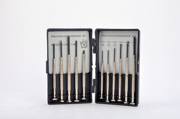 A set of small screwdrivers in a box on a white background