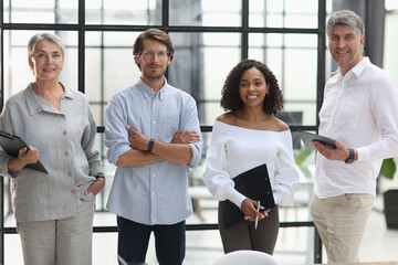 A group of young modern people in smart casual clothes, studying while working in the office