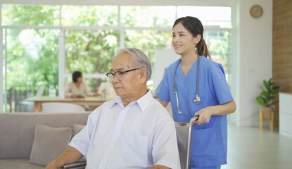 Wall Mural - An Asian nurse talking to a group of old elderly patient or pensioner people smiling, relaxing, having fun together in nursing home. Senior lifestyle activity recreation. Retirement. Health care